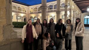 Grupo de mujeres posando de noche en un claustro iluminado