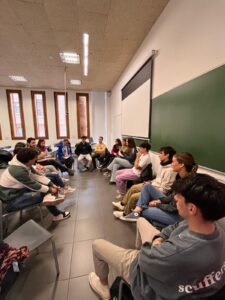 Jóvenes sentados en círculo en un aula durante un coloquio