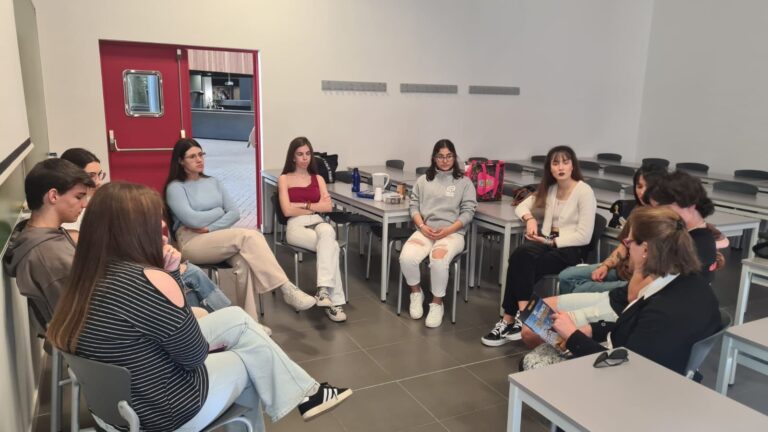 Grupo de jóvenes conversando sentados en círculo en un aula