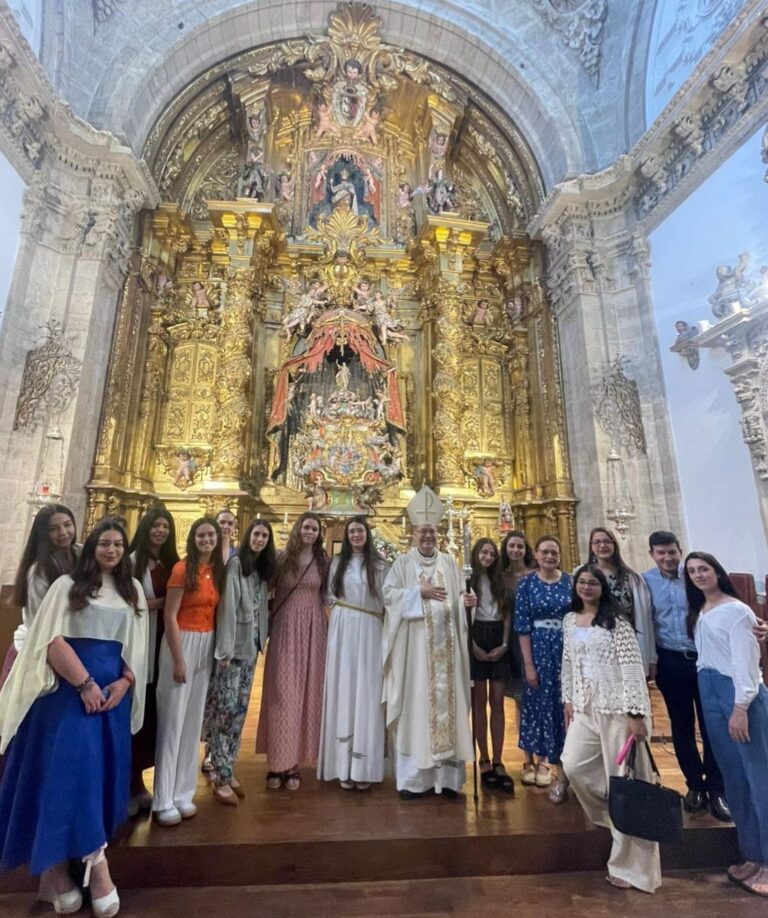Grupo de jóvenes con celebrantes ante un gran retablo barroco